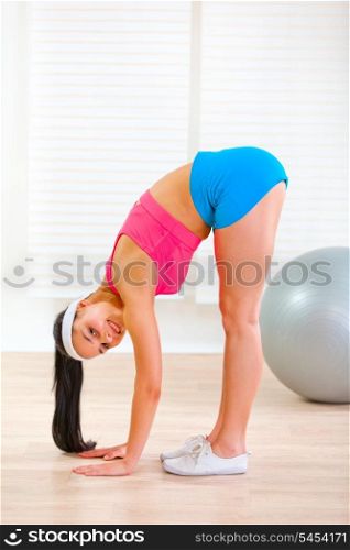 Smiling pretty girl doing stretching exercises at home&#xA;