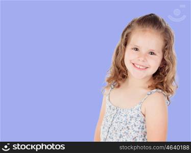 Smiling pretty little girl with curly hair looking at camera on blue background