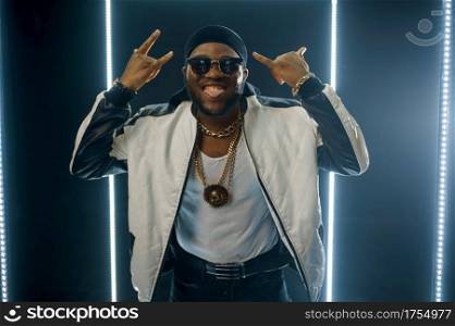 Smiling rapper on the stage with illuminated cube. Hip-hop performer, rap singer, break-dance performing, entertainment lifestyle. Smiling rapper on the stage with illuminated cube
