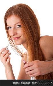 Smiling red hair woman applying lipstick on white background