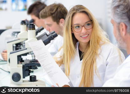 Smiling science student talking with teacher