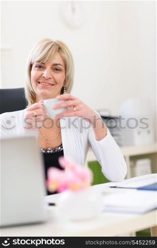 Smiling senior business woman having coffee break