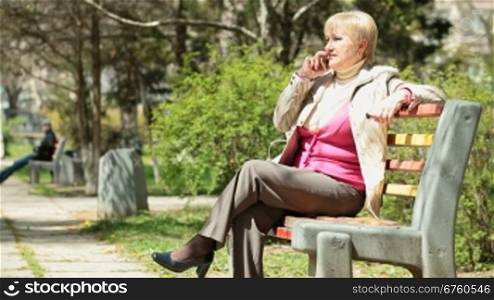 Smiling senior woman talking on cellphone outdoors