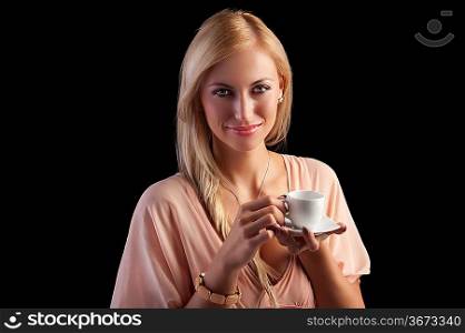 smiling sensual blond girl with hair style holding a coffee set in elegant pink dress over dark fashion background