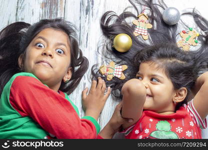 Smiling sisters decorating their hair with Christmas decorations