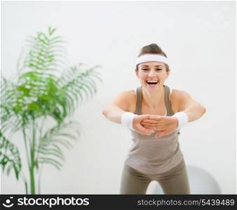 Smiling slim woman making stretching exercises