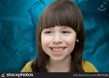 Smiling small boy head portrait on blue background