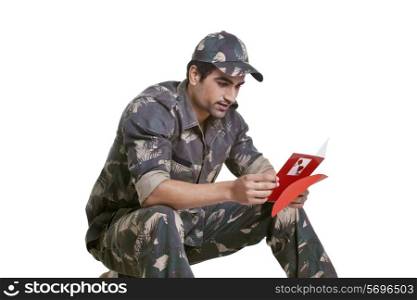 Smiling soldier reading greeting card