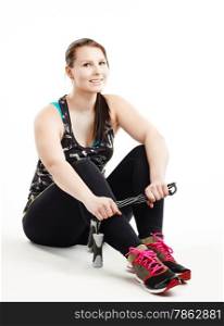 Smiling sporty girl wearing a sportswear and she holding a skipping rope, white background