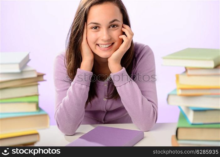 Smiling student girl between piles of books on white background