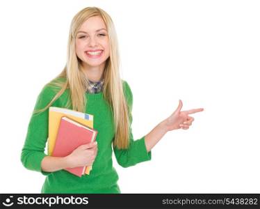 Smiling student girl with books pointing on copy space