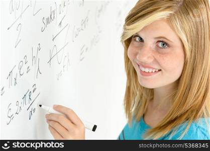 Smiling student teenage girl writing mathematics white board looking camera