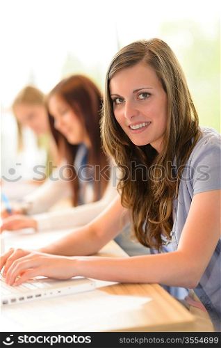 Smiling student teenager studying at classroom high school