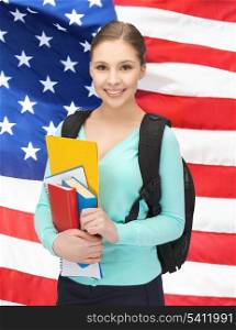 smiling student with books and schoolbag over american flag