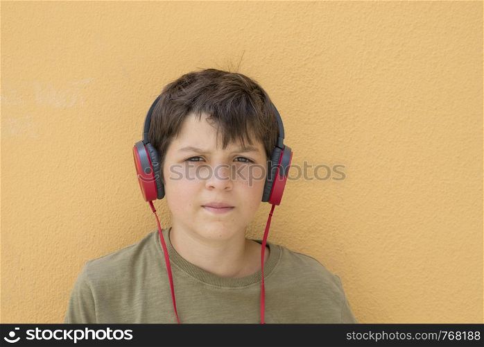 Smiling teen boy posing outdoors. Looking at camera with headphones