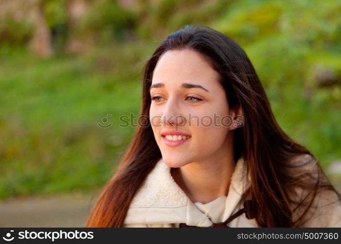 Smiling teen girl outside with a natural green of background