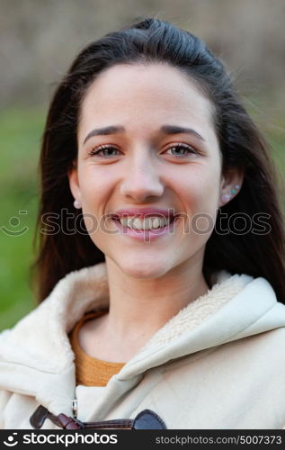 Smiling teen girl outside with a natural green of background