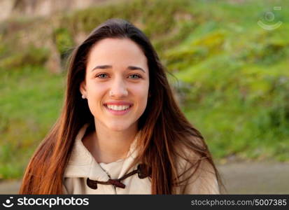 Smiling teen girl outside with a natural green of background