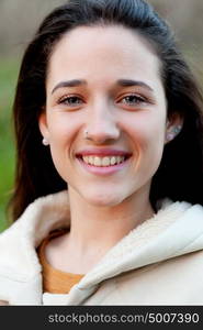 Smiling teen girl outside with a natural green of background