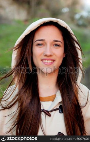 Smiling teen girl outside with a natural green of background