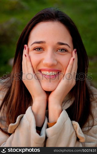 Smiling teen girl outside with a natural green of background