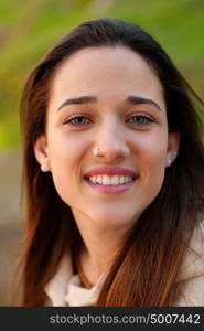 Smiling teen girl outside with a natural green of background