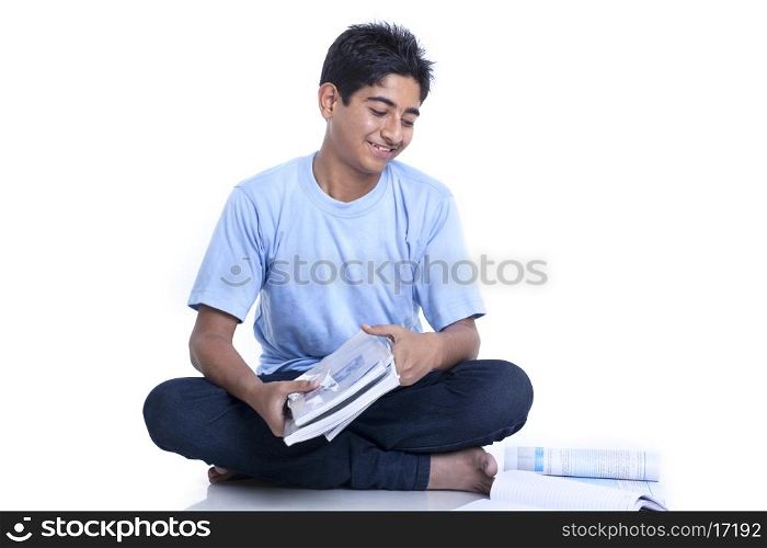 Smiling teenage boy with books against white background