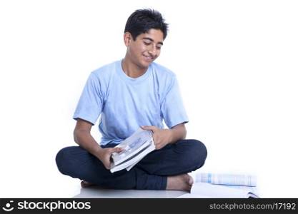 Smiling teenage boy with books against white background