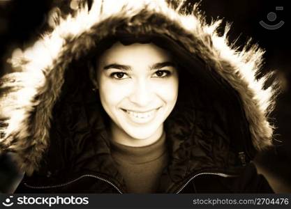 Smiling teenage girl in coat with fur trimmed hood