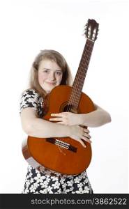 smiling teenage girl in dress holds guitar in studio with white background