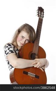 smiling teenage girl in dress holds guitar in studio with white background