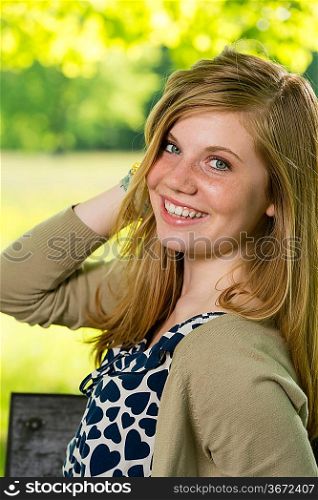 Smiling teenage girl posing outdoors looking at camera