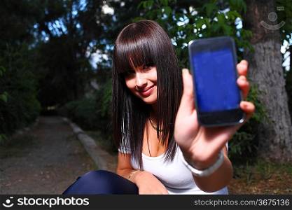 smiling teenage girl shows cell
