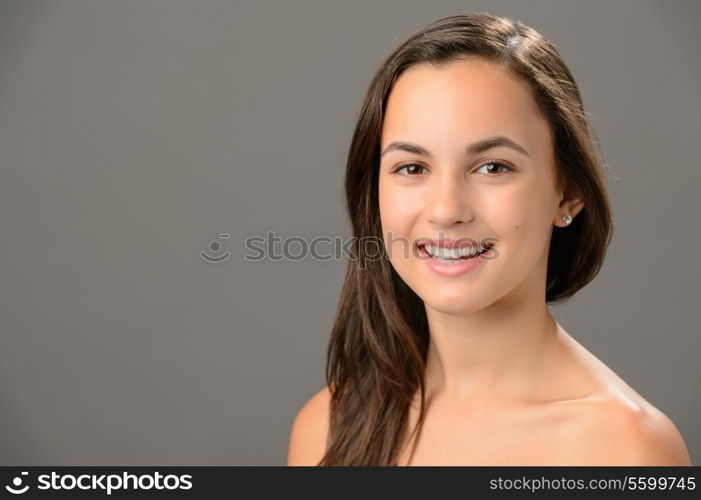 Smiling teenage girl skin care beauty brunette portrait on gray background