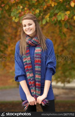 Smiling Teenage Girl Standing In Autumn Park