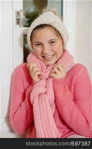smiling teenage girl with a pink sweater and winter hat