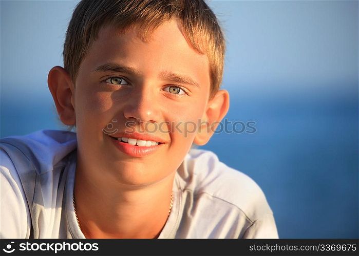 smiling teenager boy against sea
