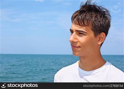 smiling teenager boy against sea, Looking afar