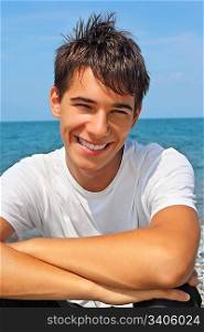 smiling teenager boy against sea, Looking at camera