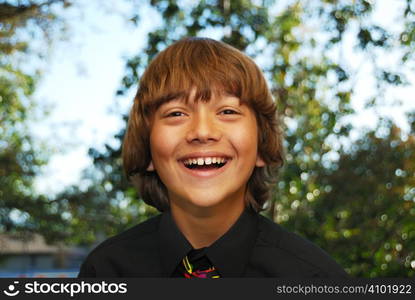 Smiling teenager dressed up in a black shirt and tie.