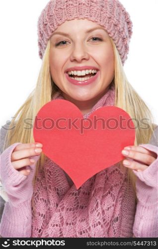 Smiling teenager girl in winter hat and scarf showing heart shaped postcard