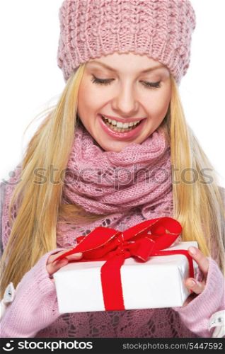 Smiling teenager girl in winter hat and scarf with presenting box