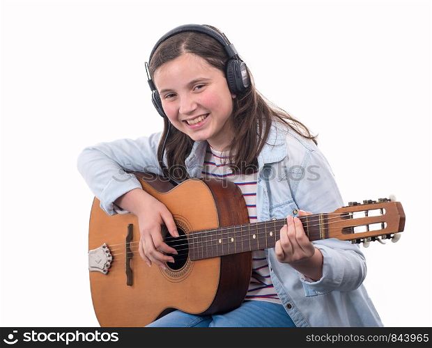 smiling teenager girl playing acoustic guitar on white background