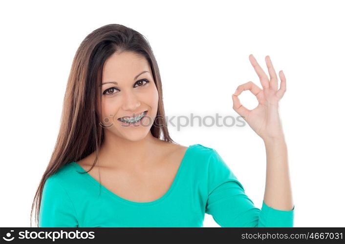Smiling teenager girl with brackets saying Ok isolated on a white background