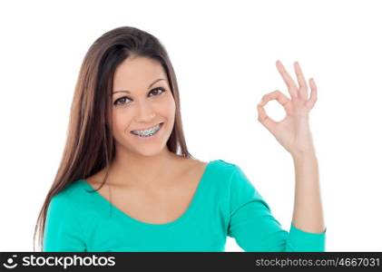 Smiling teenager girl with brackets saying Ok isolated on a white background