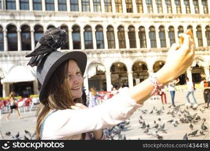 smiling teenager girl with dove on Piazza San Marco, venice. Italy