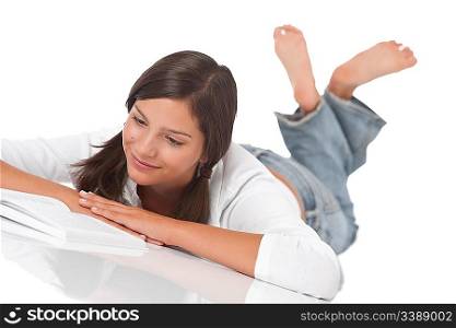 Smiling teenager reading book on white background