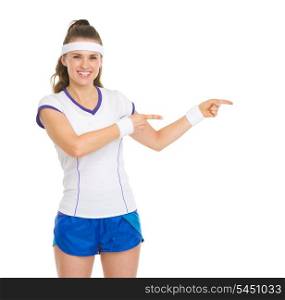 Smiling tennis player pointing on copy space