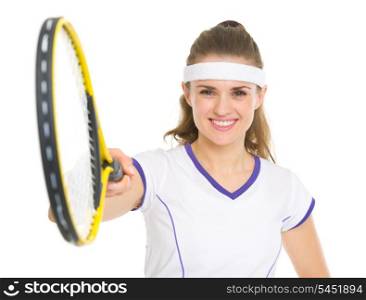 Smiling tennis player pointing racket in camera