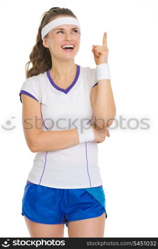 Smiling tennis player pointing up on copy space
